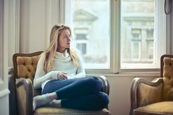 woman sitting on chair by window